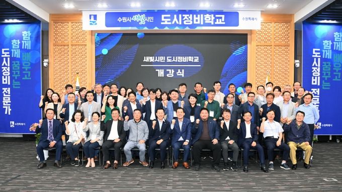 수원시가 도시정비를 주민 중심으로 추진하기 위해 도시정비 전문가를 양성하는 도시정비학교 개강식에서 참석자들이 기념촬영을 하고 있다.