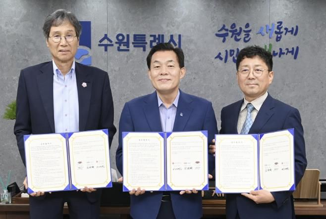 지난해 7월 이재준 수원시장(가운데, 수원시자원봉사센터 이사장)과 최순호 수원FC 단장, 김상연 수원경제정의실천시민연합 공동대표가 새벽빛 장애인 야학 지원을 위한 업무협약 후 기념촬영을 하고 있다.