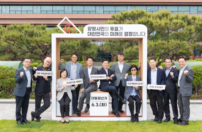 박승원 광명시장(사진 왼쪽에서 여섯번째)이 19일 시청 앞 잔디광장에 설치된 투표 참여 조형물에서 기념사진을 촬영하고 있다.