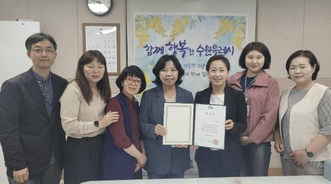 김은주 수원시 여성가족국장(오른쪽 3번째)과 직원들이 표창장을 들고 기념촬영을 하고 있다.