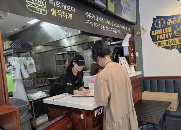 성남시 어린이 기호식품 전담관리원이 지난 9월 학교 주변 햄버거 판매점에서 영업자와 종업원의 건강진단 실시 여부를 점검하고 있다