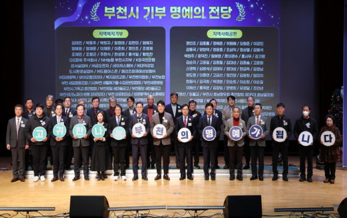 명예의 전당 등재자들과 부천시장이 종무식 무대에서 기념사진을 찍고 있다.